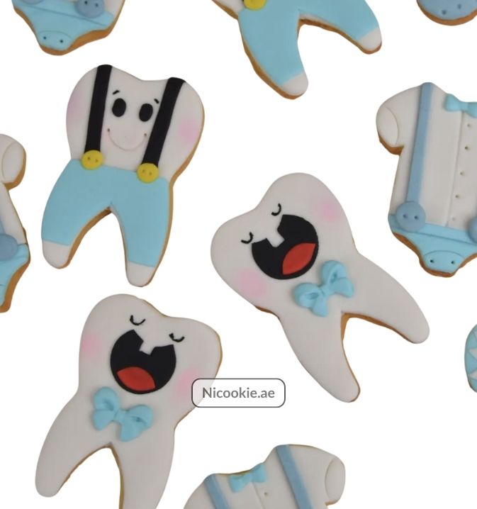 Tooth-shaped cookies with blue overalls and suspenders.