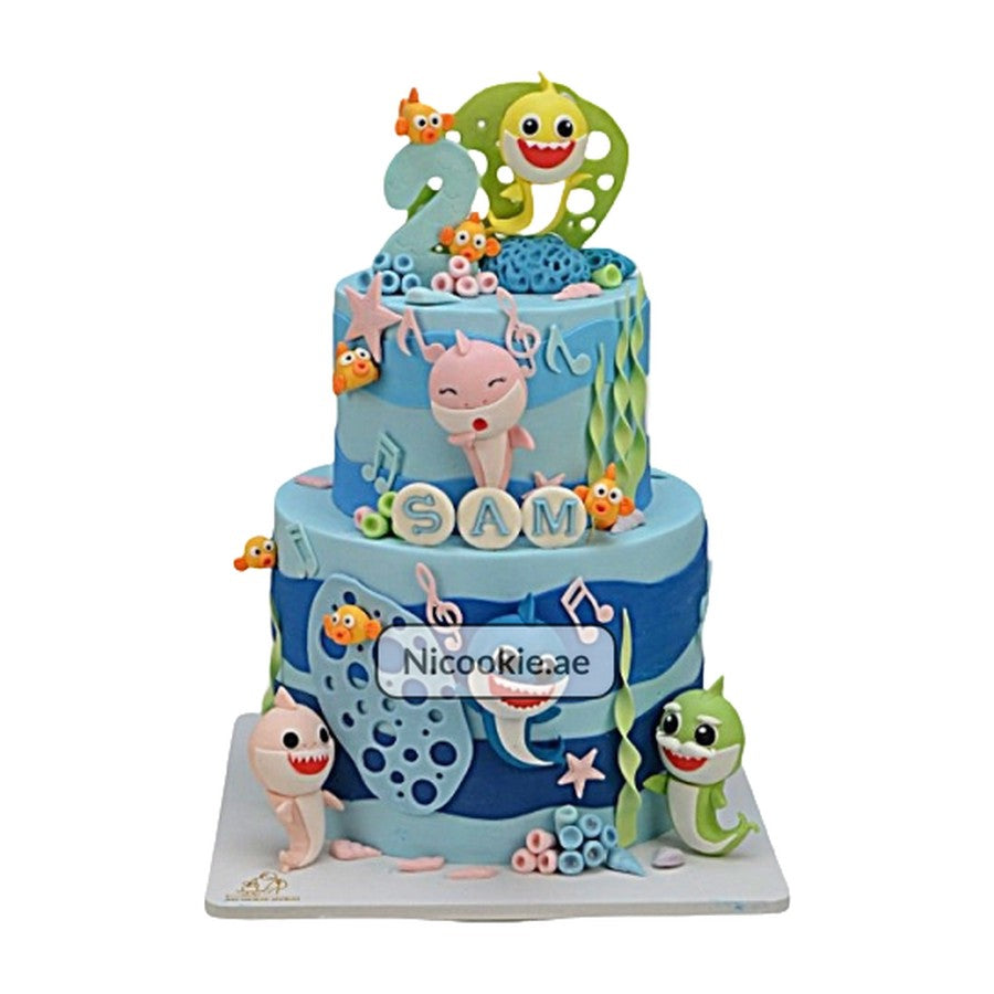 Two-tiered Baby Shark cake with underwater decorations and the name Sam.