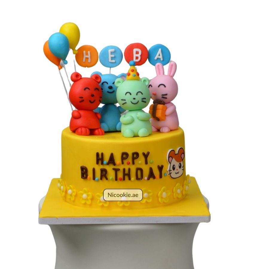 Yellow birthday cake with cute animal figurines and balloons.