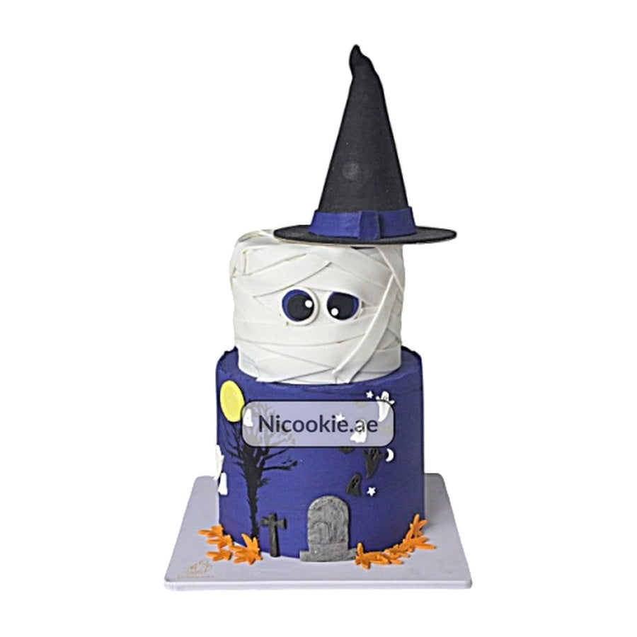 Halloween mummy cake with a witch hat and graveyard scene.