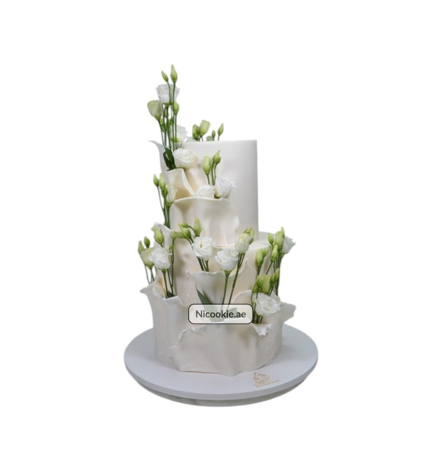 Ivory Blossom Tower cake with white flowers and ruffled layers.