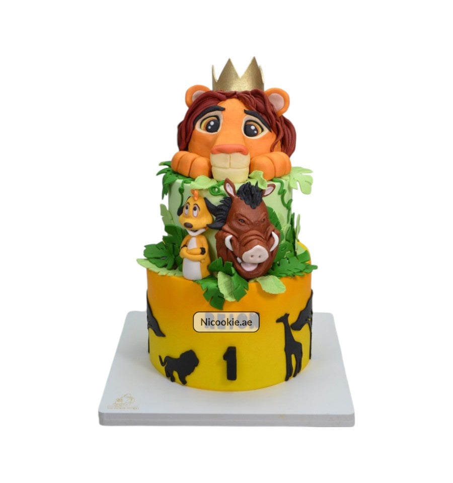 A three-tiered jungle-themed cake featuring a crowned lion, Timon, and Pumbaa.