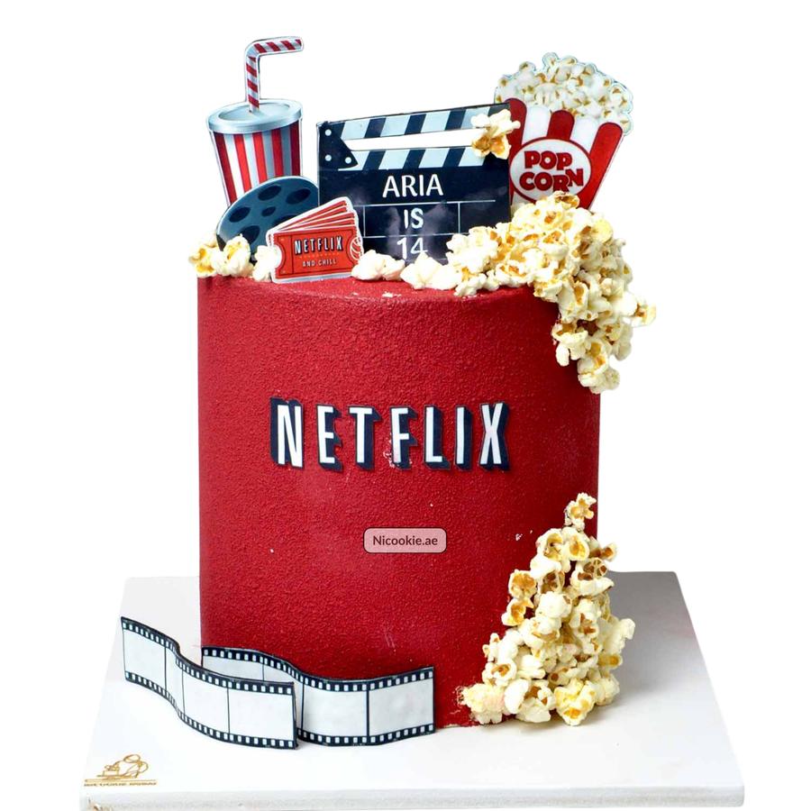 A red Netflix-themed cake decorated with popcorn and movie elements.