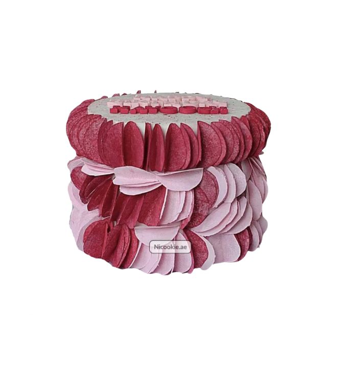 A pink ombre petal cake with a personalized message on top.