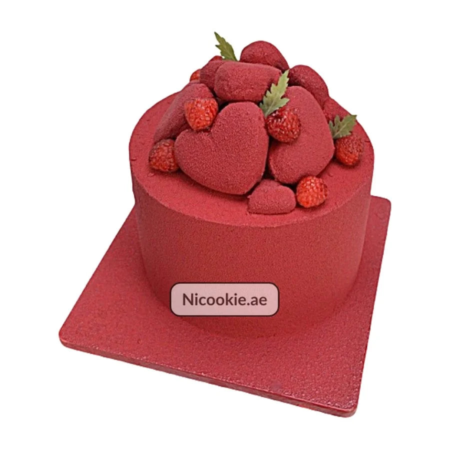 Red velvet cake topped with red velvet hearts and berries.