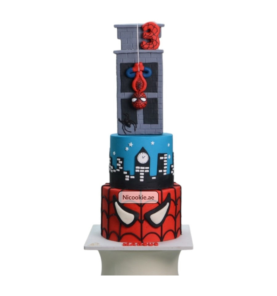 A three-tiered Spider-Man cake with a cityscape and building design.
