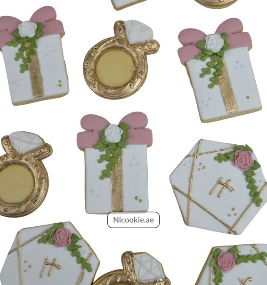 Golden Elegance cookies shaped like gifts, rings, and hexagons with floral and bow details.