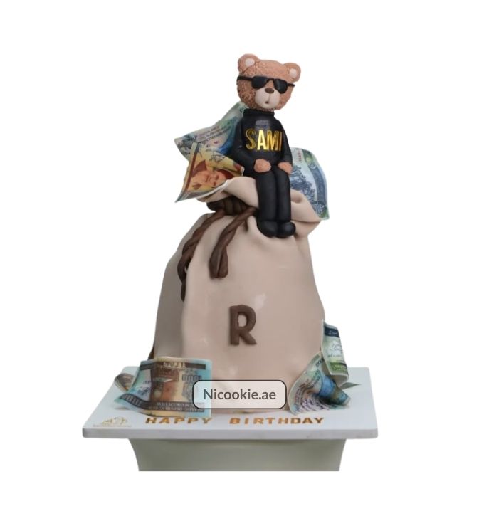 Teddy bear cake with money bag and currency decorations.