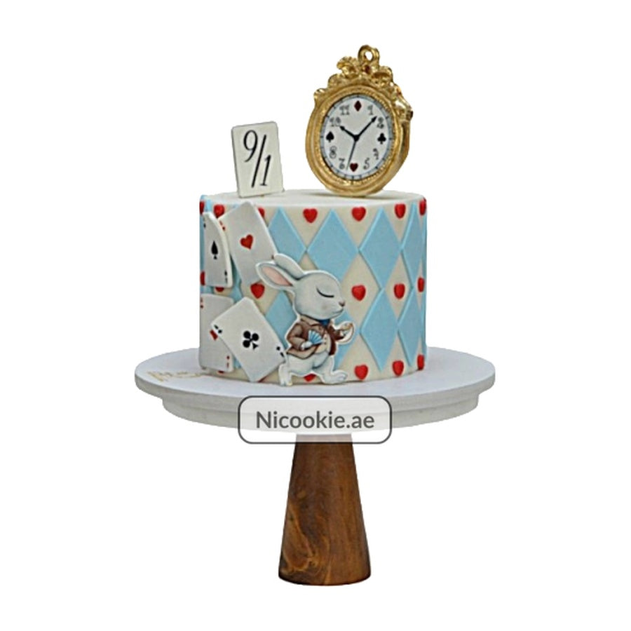 Alice in Wonderland cake with white rabbit, playing cards, and a golden clock.