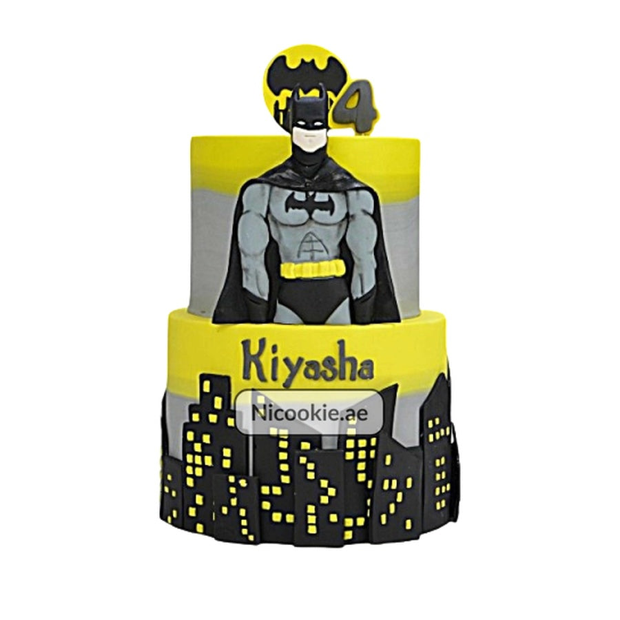 A two-tiered Batman cake with a city skyline and a Batman figure.