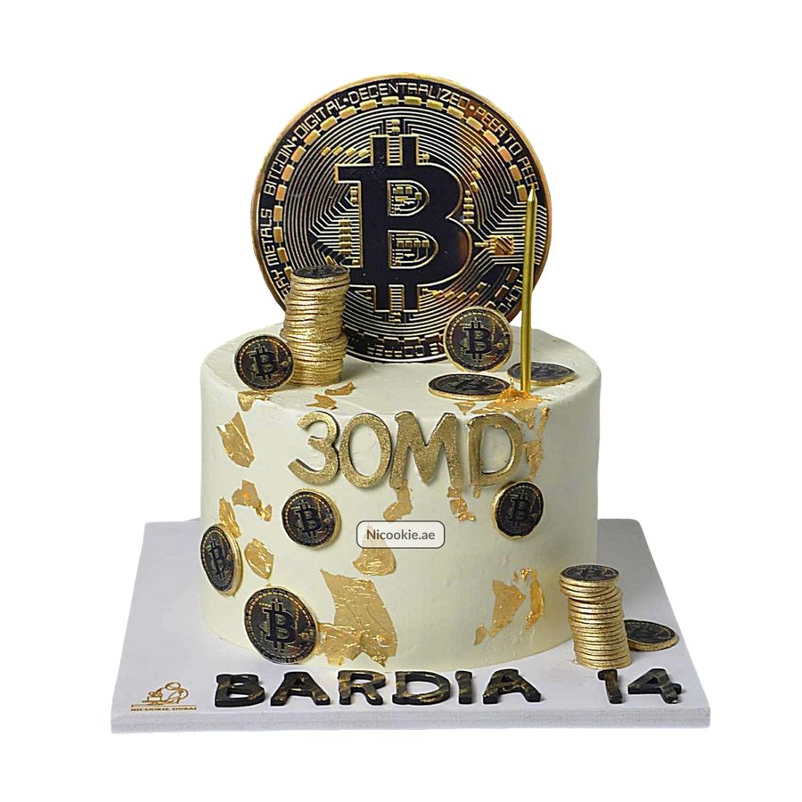 A white cake decorated with gold leaf, Bitcoin coins, and a large Bitcoin topper.