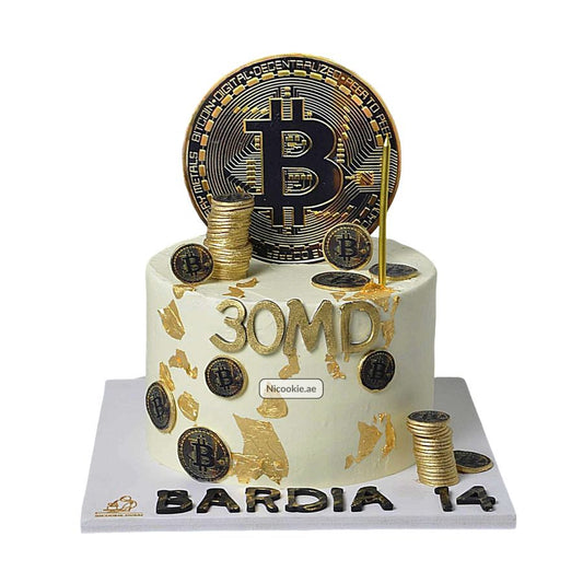 A white cake decorated with gold leaf, Bitcoin coins, and a large Bitcoin topper.