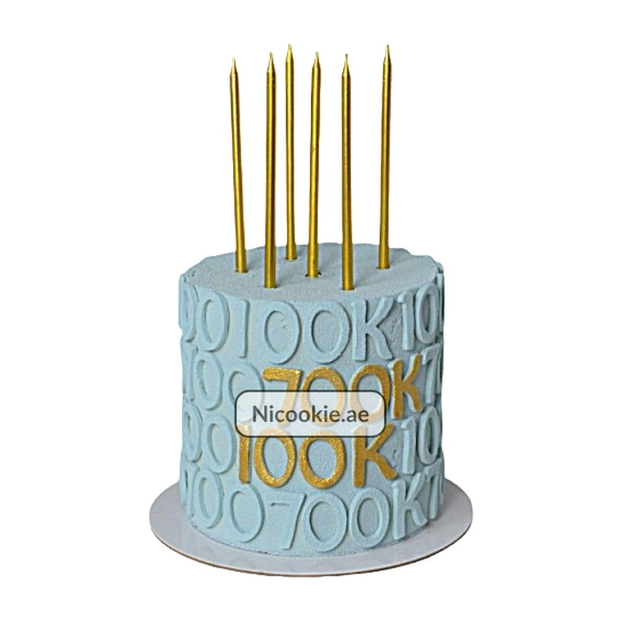 Blue 700K milestone celebration cake with gold candles.