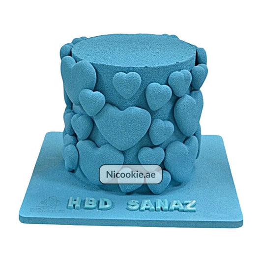 Blue cake decorated with blue velvet hearts and "HBD SANAZ" on the base.