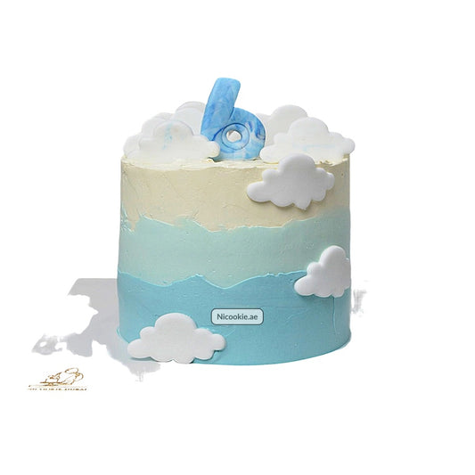 A blue and cream ombre cake decorated with white clouds and a blue number 6.