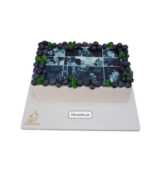 Rectangular cake with a photo mosaic, blueberries, and mint leaves.