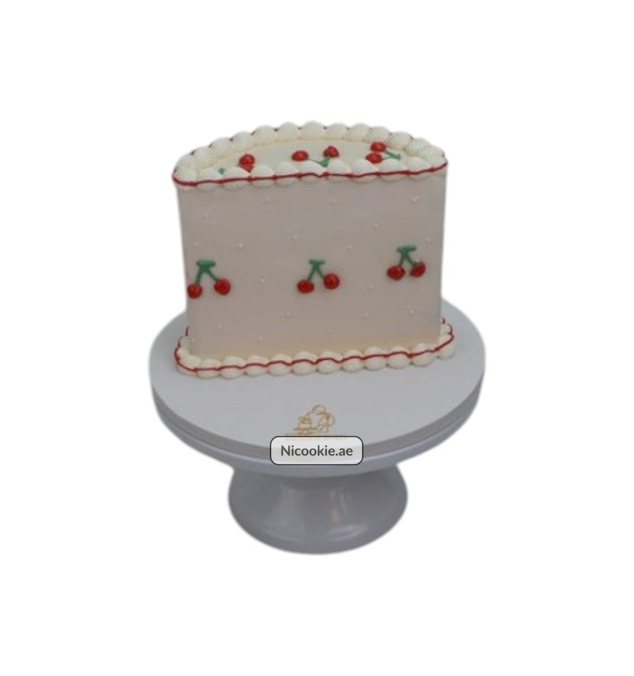 A rectangular cake decorated with red cherries and white piping.