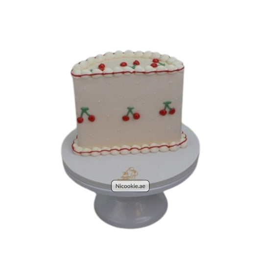 A rectangular cake decorated with red cherries and white piping.