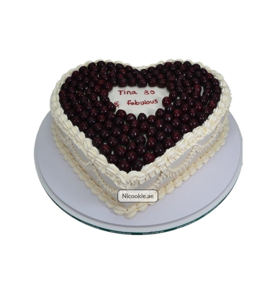 Heart-shaped cake with cherries and cream frosting, celebrating Tina's 30th birthday.