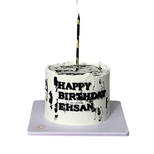 A white birthday cake with black brushstrokes, "Happy Birthday Ehsan" text, and a black and gold candle.