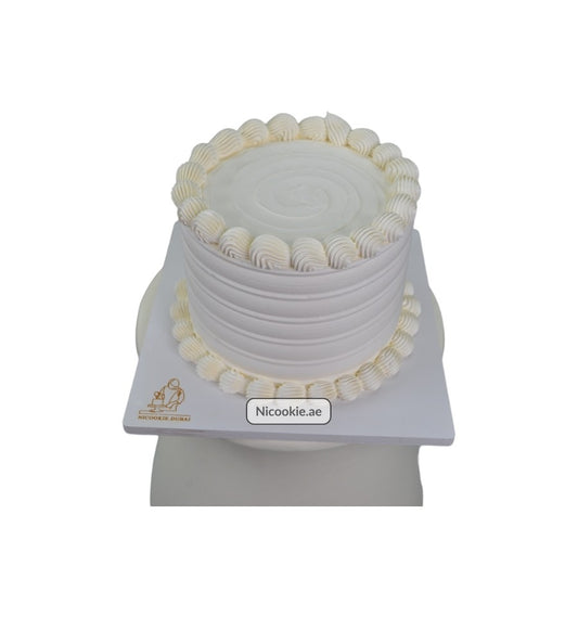Classic vanilla swirl cake with white frosting and decorative piping.