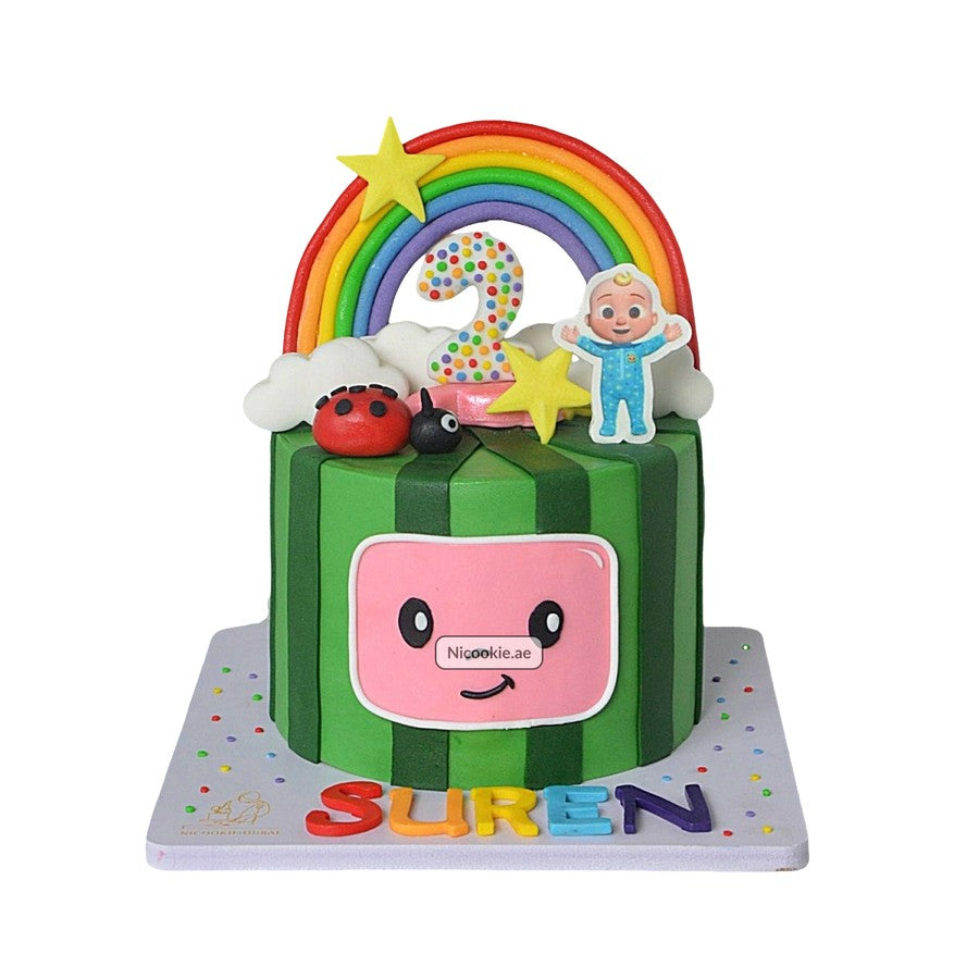 A watermelon-themed birthday cake with a rainbow, number 2, and a baby figure.