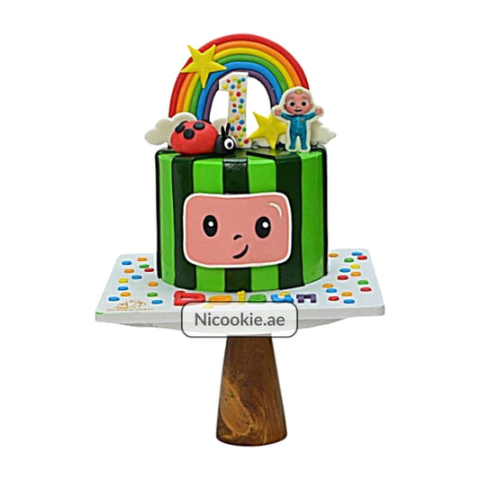 Cocomelon cake with rainbow, number 1, and character toppers.