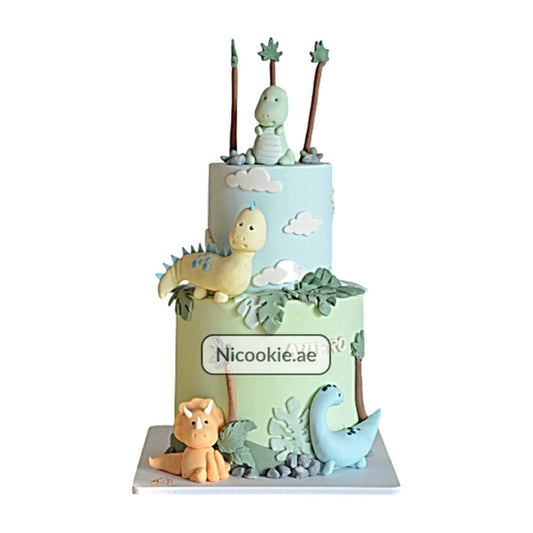 A two-tier dinosaur forest cake with fondant dinosaurs and palm trees.