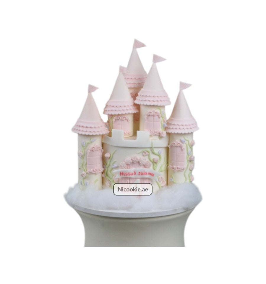 Pink enchanted castle cake with floral decorations and flags.