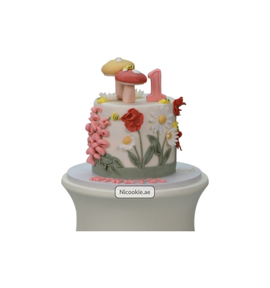Enchanted Garden cake with fondant flowers, mushrooms, and a number 1 topper.