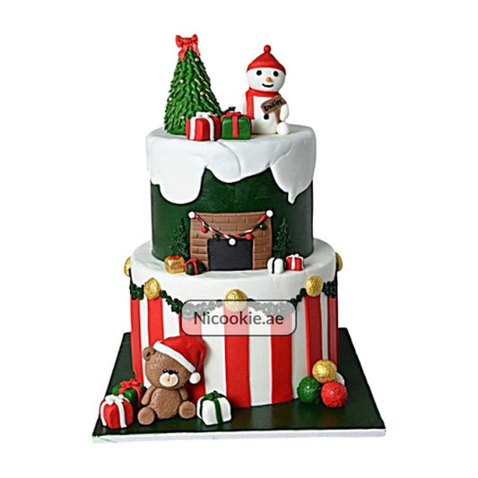 Festive two-tiered Christmas cake with snowman, fireplace, and teddy bear decorations.