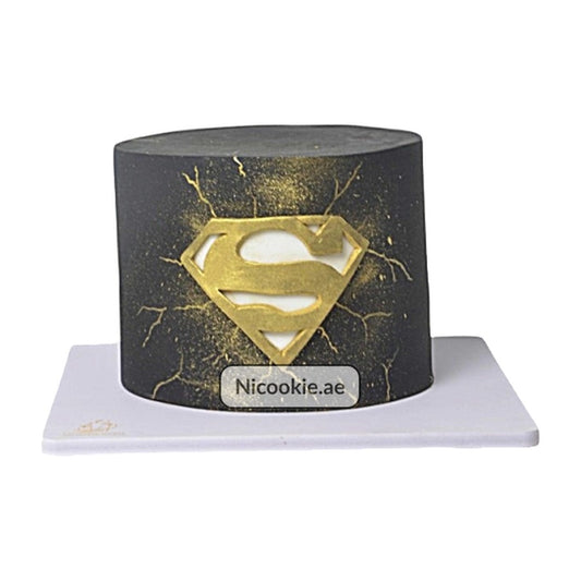 Gold Superman cake with black fondant and gold splatter.