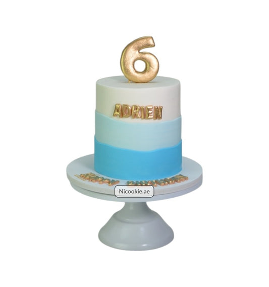 Golden blue ombre cake with "ADRIEN" and a number 6 topper.