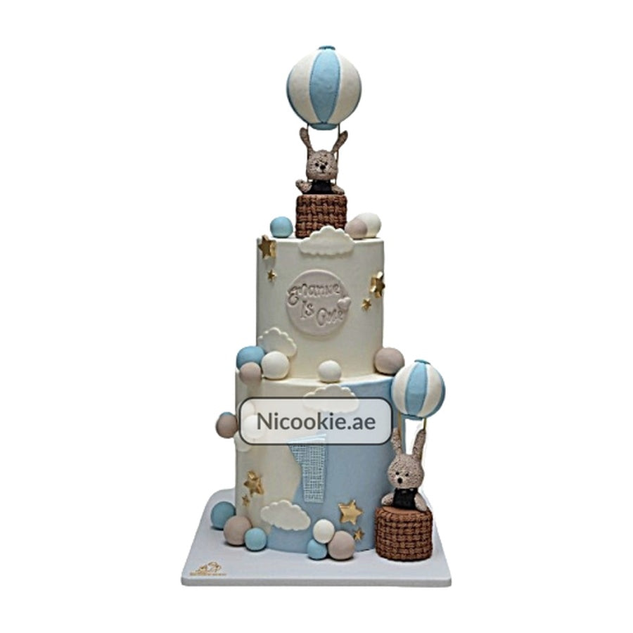 A three-tier cake with hot air balloon and bunny decorations.