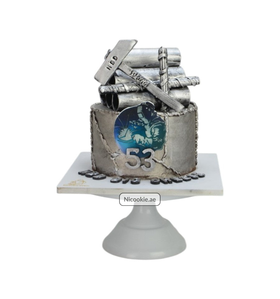Industrial explorer cake with metallic accents and a welder motif.