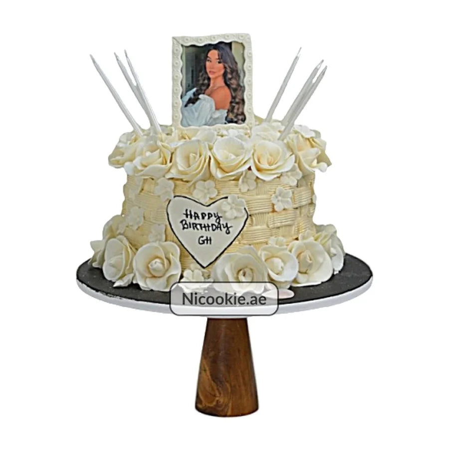 Ivory Queen cake with ivory roses, photo frame, and candles.