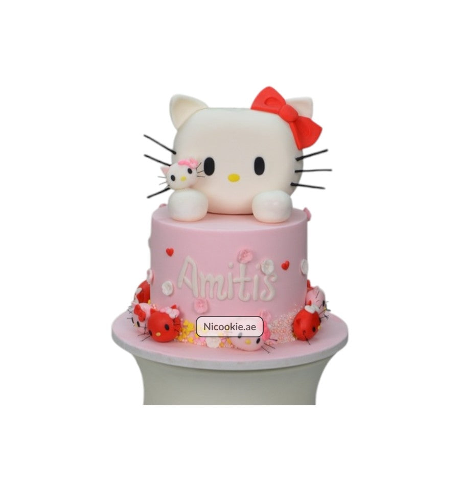 A pink Hello Kitty cake with a red bow and a smaller Hello Kitty figure.
