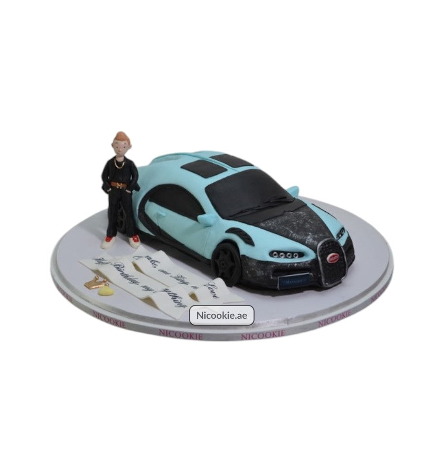 A light blue luxury car cake with a fondant figure and a birthday message.