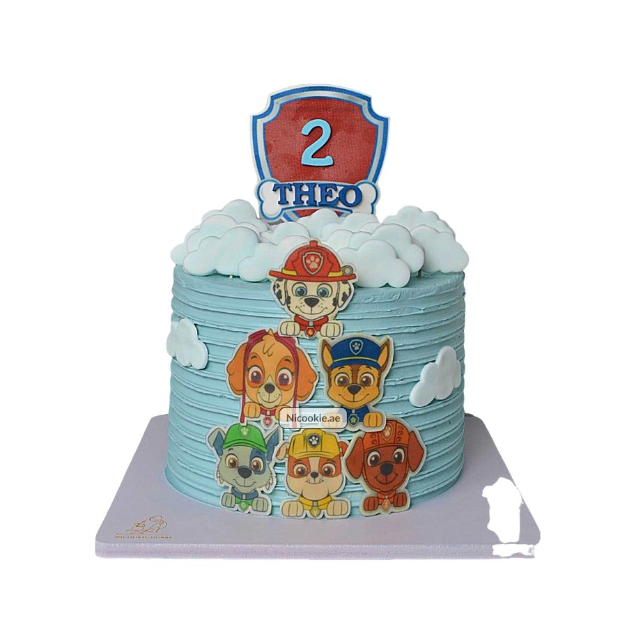 Paw Patrol cake with blue frosting, clouds, and character toppers.