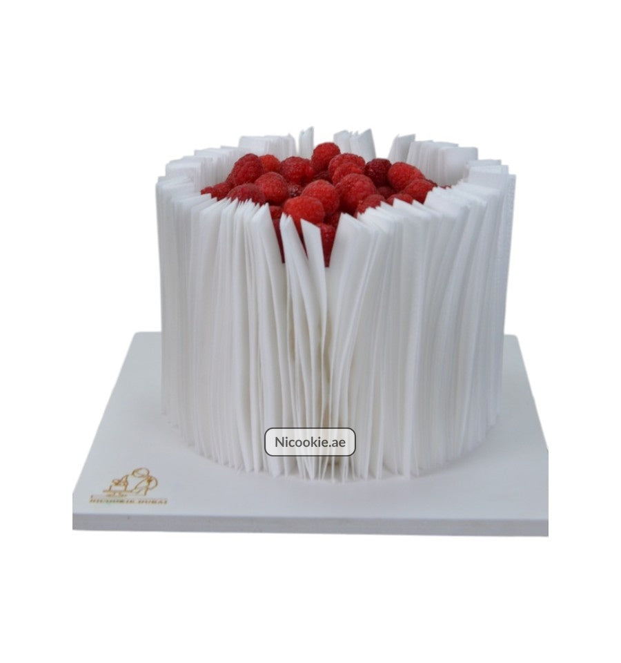 Raspberry Paper Elegance cake with white paper-like frosting and fresh raspberries.