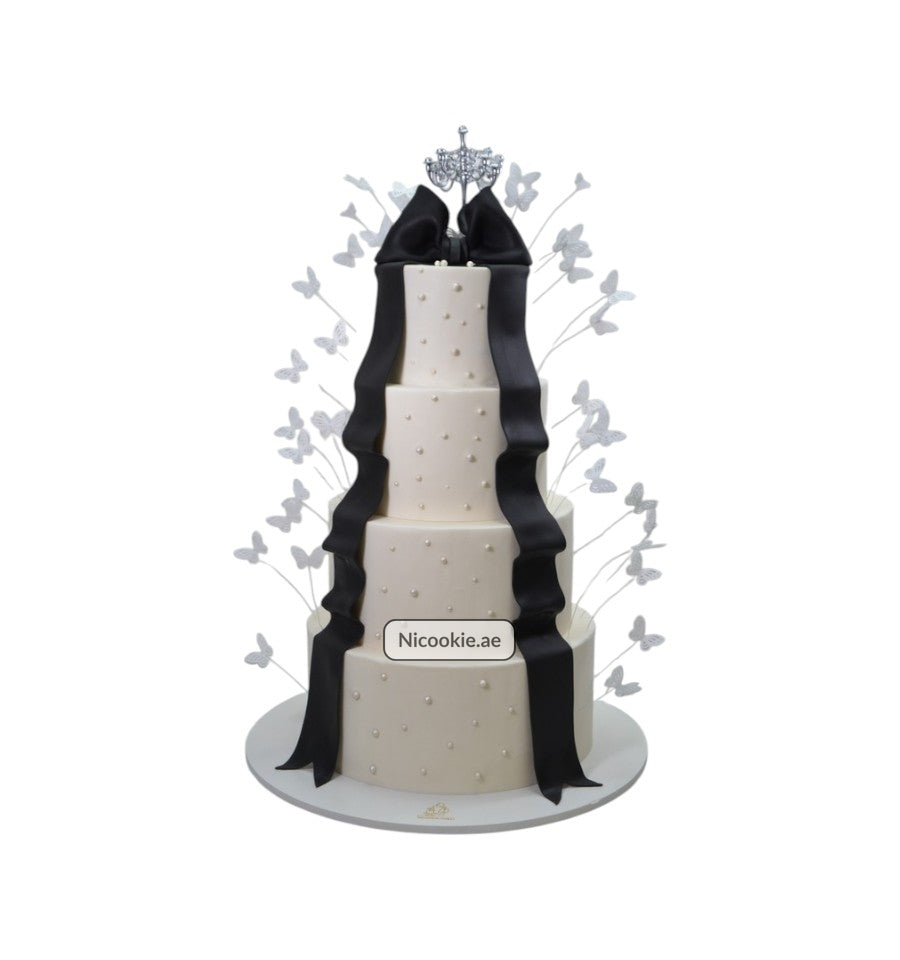 Regal black tie cake with a crown topper and black ribbon.