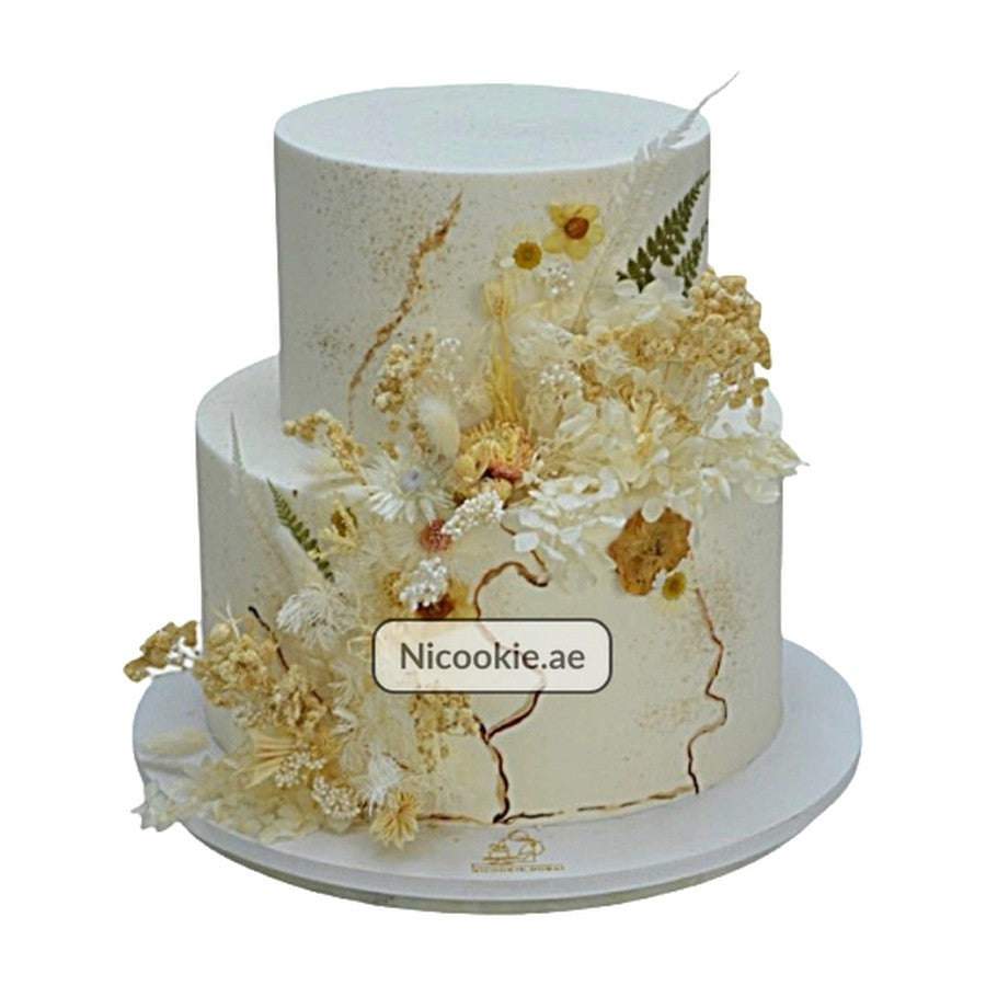 Rustic dried flowers cake with gold accents and a feather.