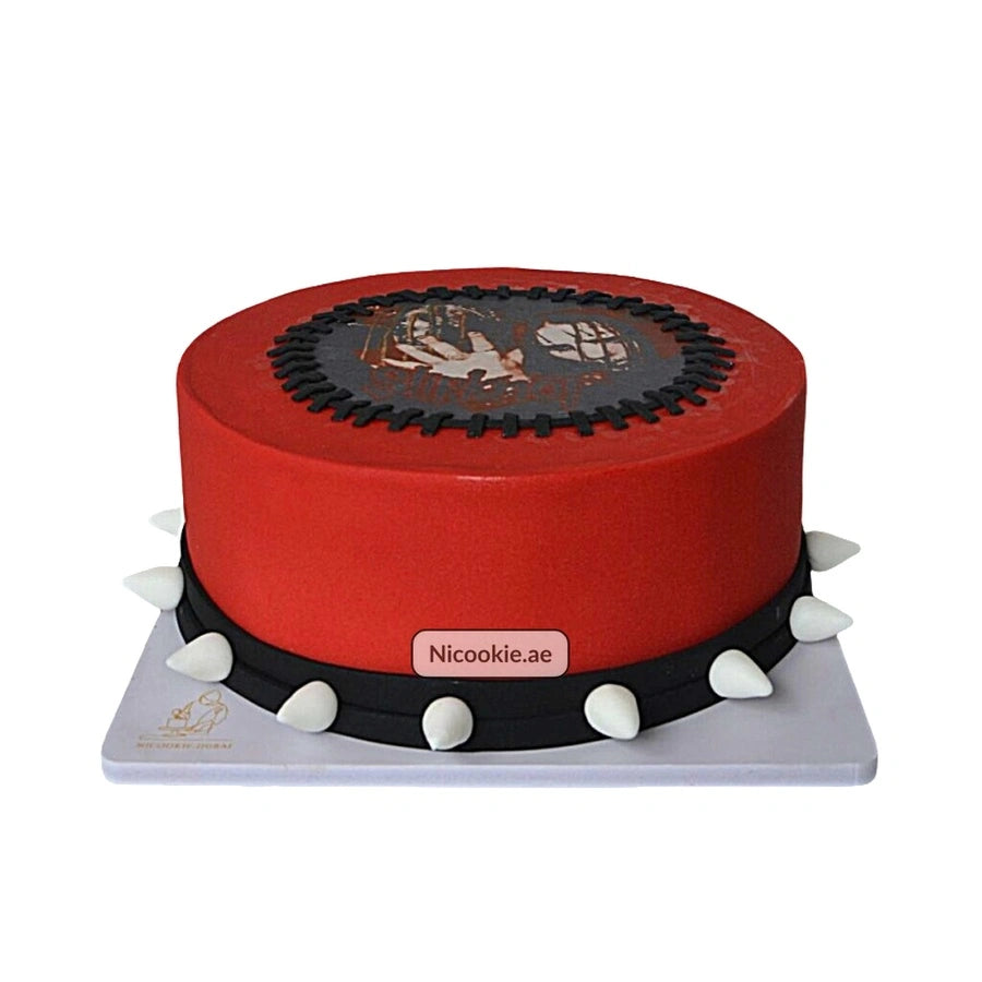 A red cake with a black band and white spikes, topped with a Slipknot logo.