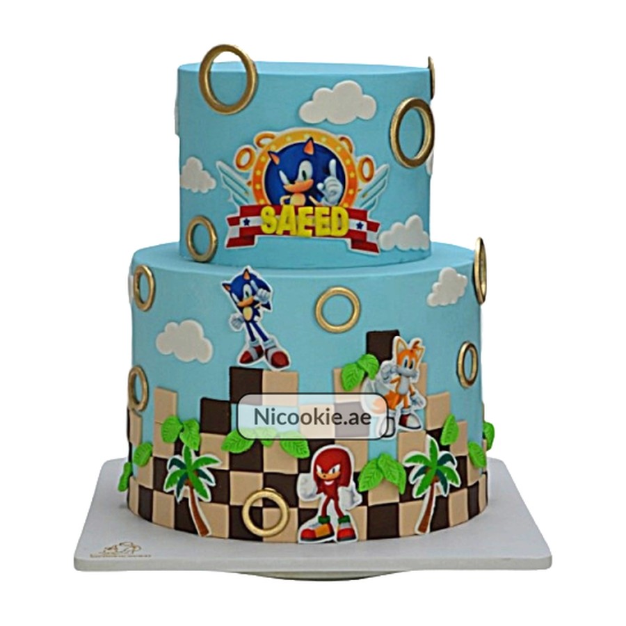 Sonic video game themed two-tier cake with characters and gold rings.