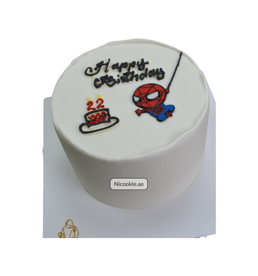 A white cake decorated with "Happy Birthday", a Spider-Man swinging, and a cake with candles.