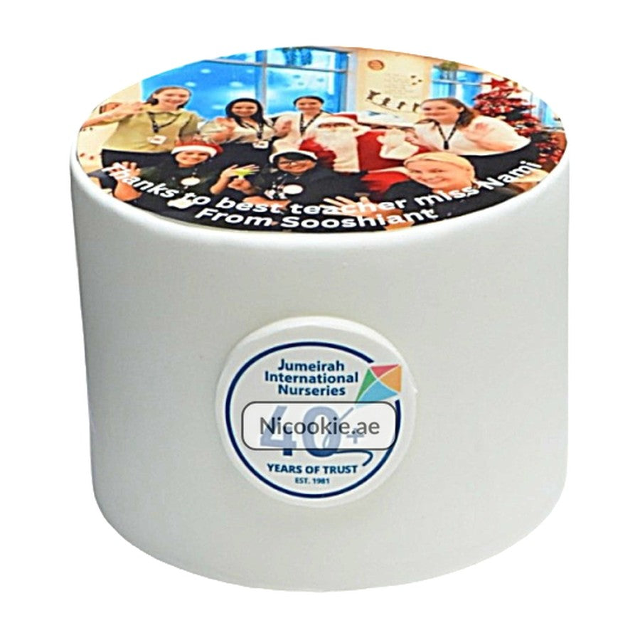 White cake with a personalized photo of children and Santa on top.