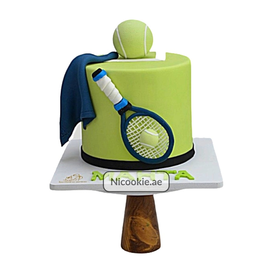 A tennis-themed cake with a racket, ball, and towel decoration.
