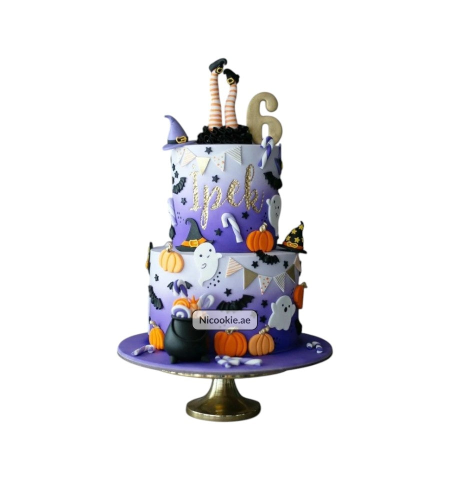A two-tier Halloween cake decorated with ghosts, pumpkins, and witch elements.